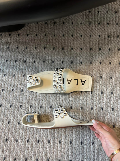 ALAIA FOLDED FLAT MULES WITH SPHERES ON WHITE CALFSKIN