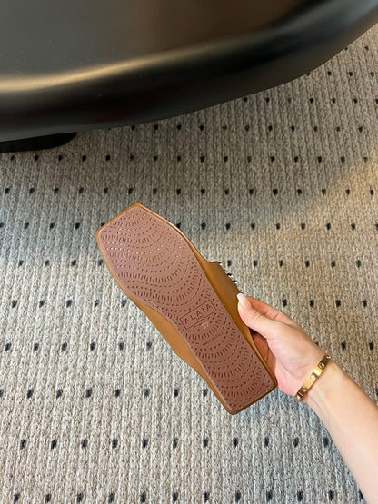 ALAIA FOLDED FLAT MULES WITH SPHERES ON COPPER BROWN CALFSKIN
